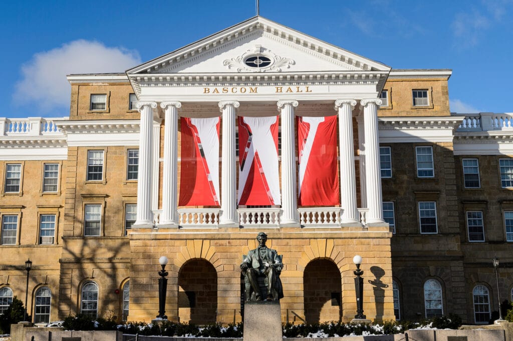 W banners hang from the columns of Bascom Hall at the University of Wisconsin-Madison during winter on Dec. 9, 2016. In the foreground is the Abraham Lincoln statue. (Photo by Jeff Miller/UW-Madison)